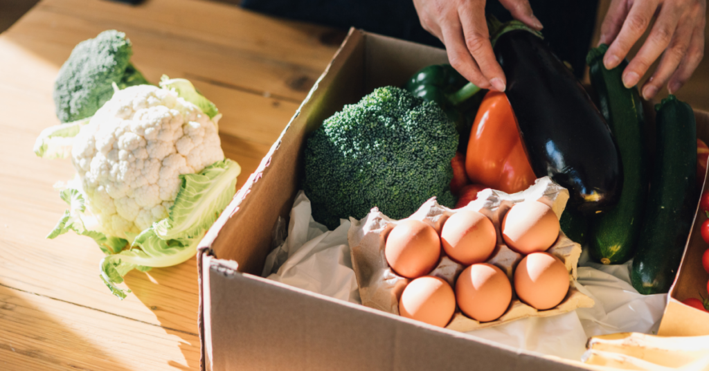 Foto ilustrativa de um pacote de alimentos orgânicos sendo entregue por serviço de delivery, trazendo sabor e saúde diretamente à sua porta