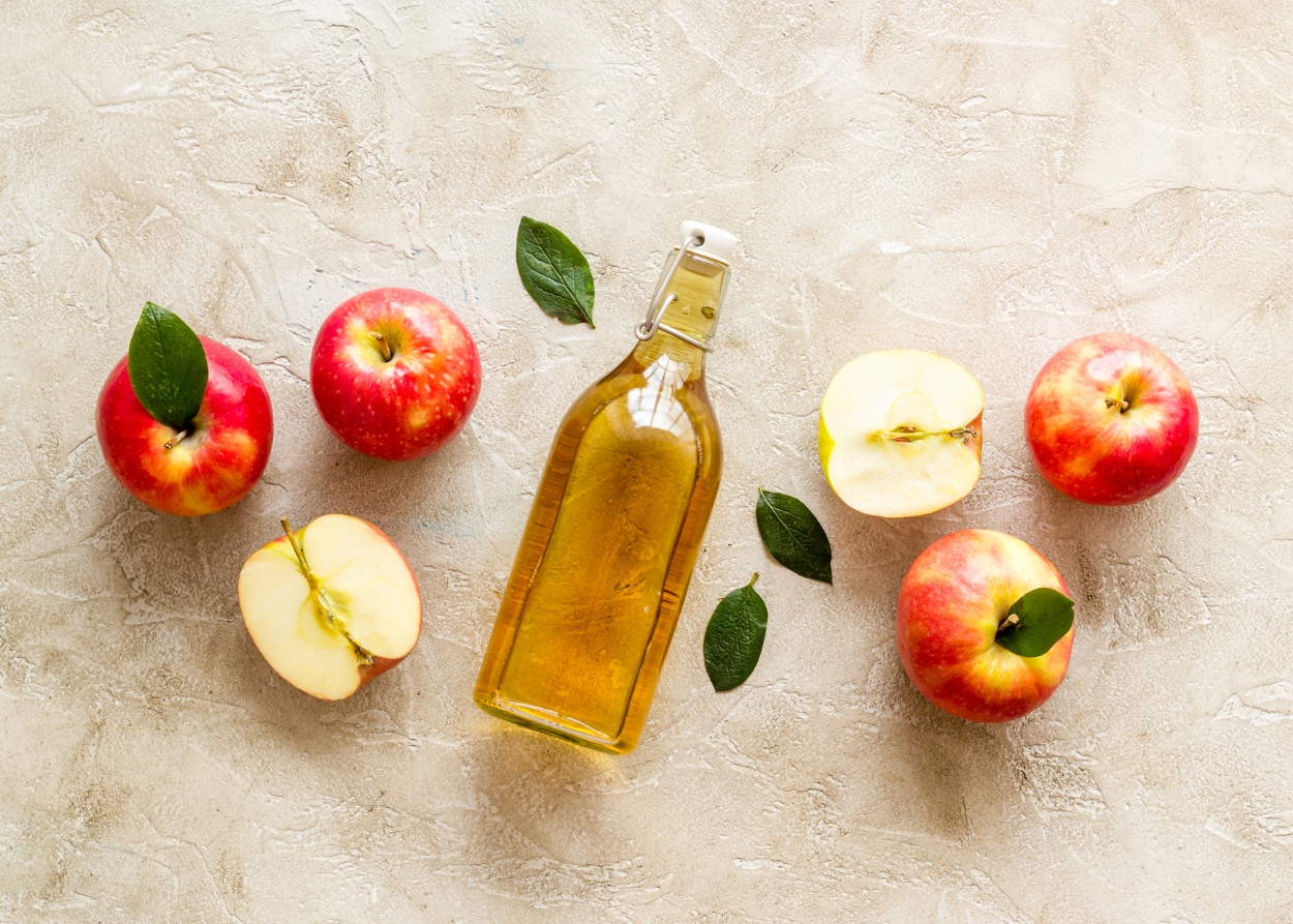 Close-up de vinagre de maçã orgânico com maçãs frescas
